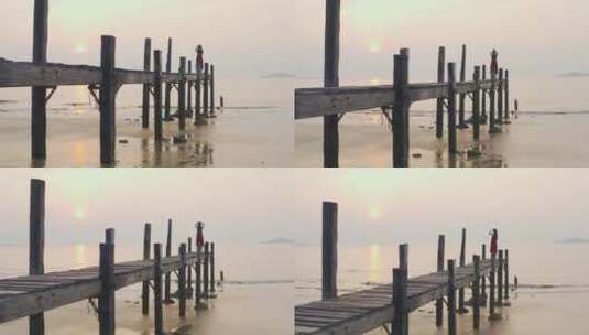 大海边站在木桥看日出的女孩，海水激起浪花高清在线视频素材下载